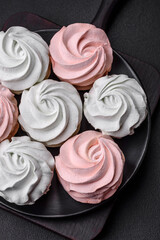 Delicious sweet multi-colored marshmallow on a dark concrete background