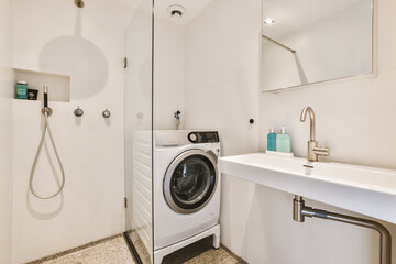 a laundry room with a washer and dryer in the corner, there is a mirror on the wall