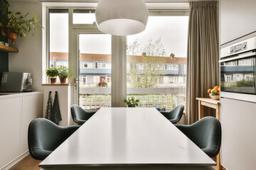 a dining table and chairs in a room with large windows looking out onto the cityscapearl view