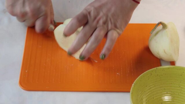 Female hands slicing pattypan squash on cutting board