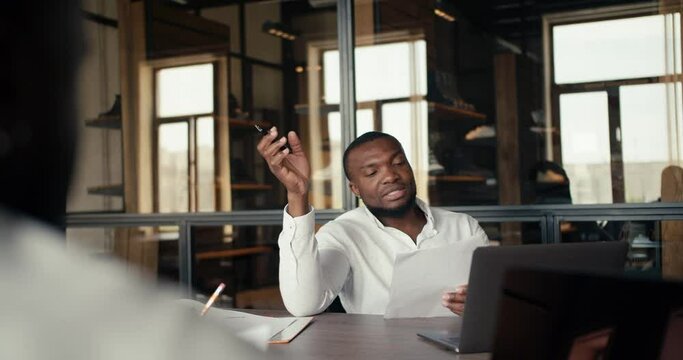 POV business meeting of two businessmen Black skinned in white shirts. Discussing a plan for a new business in a loft-style office
