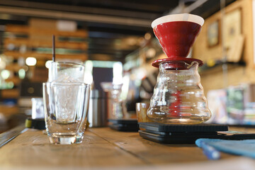 Coffee drip process by pouring hot water from kettle though ground berries bean