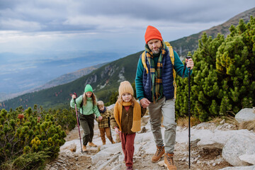 Happy family hiking together in autumn mountains.