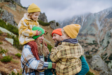 Happy family hiking together in autumn mountains.