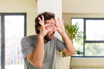 young adult crazy man with expressive pose at a modern house interior