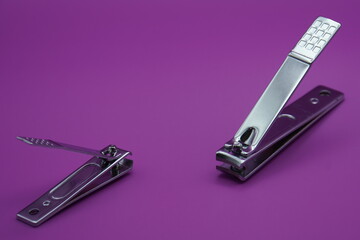 nail clipper on a purple background - obrazy, fototapety, plakaty