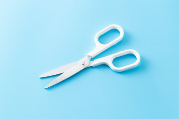 青い背景に白いハサミ