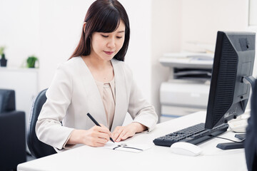 会社で葬儀の準備をする女性