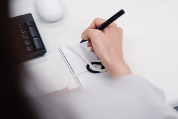 会社で葬儀の準備をする女性