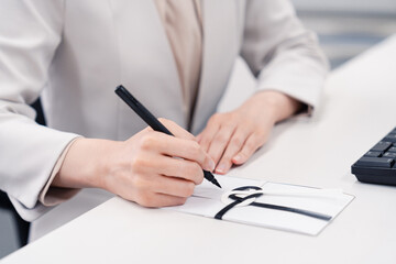 会社で葬儀の準備をする女性