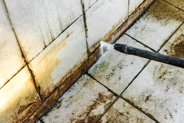 Сleaning a dirty pool with a high-pressure washer.