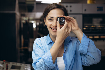 Woman working in printing house with paper and magnifying lens