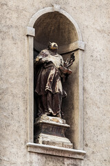 Worn and damaged statue at catholic church facade