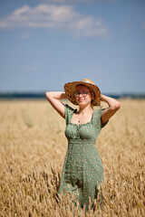 A woman in a hat in a wheat field