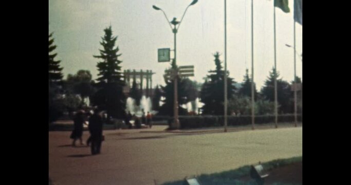 City square with colorful flags on flagpoles. People walking in town street center. Archival vintage color film. Archive video. Retro 1980s Moscow, Russia. travel landmark in tourist place. 