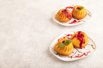 Semolina cheesecake with strawberry jam on gray concrete, side view, copy space.