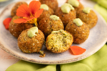 Falafel with guacamole on white concrete. Side view, selective focus.