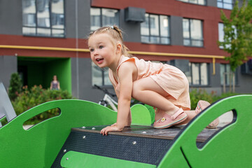 Little toddler girl having fun at playground. Concept of kindergarten and baby development. Summer