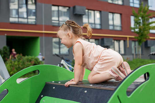 Little toddler girl having fun at playground. Concept of kindergarten and baby development. Summer