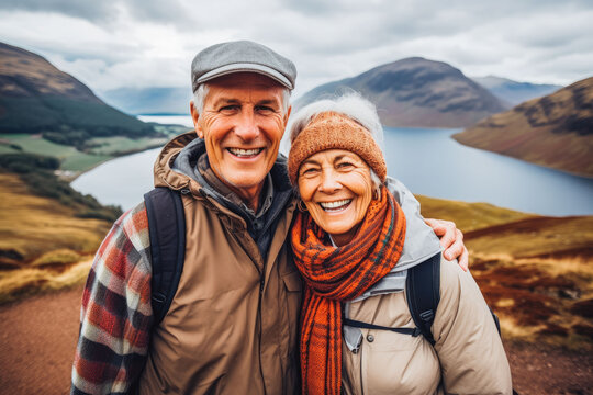 Multiethnic couple traveling in Scotland in summer. Happy older travelers exploring in nature.