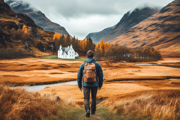 Man traveling in Scottish highlands. Happy young traveler exploring in nature. - obrazy, fototapety, plakaty