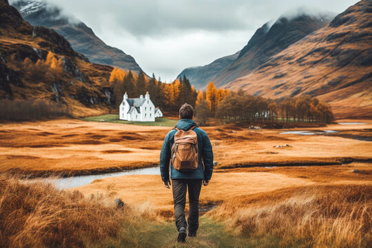 Man traveling in Scottish highlands. Happy young traveler exploring in nature.