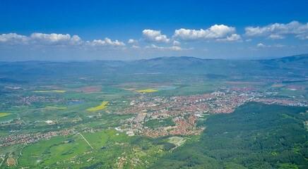 Fototapeta na wymiar Panoramic shot on the city in the mountains in early spring. Top view from a drone