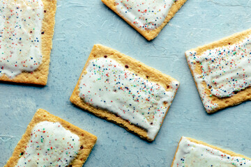 Pop tarts layout. Poptart toaster pastry with icing on a blue slate background, overhead flat lay shot