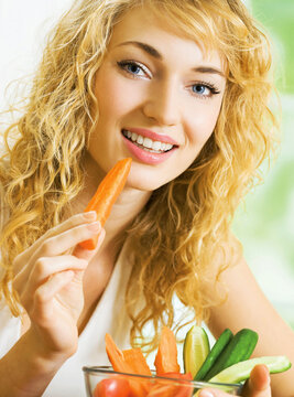 Young woman eating vegetables