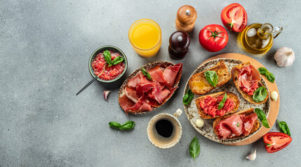 Spanish breakfast. Jamon Iberico ham and tomate bread with coffee and juice on a light background. Long banner format. top view