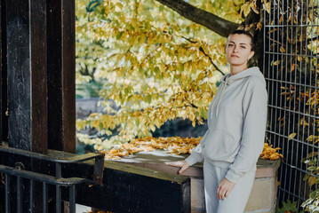 Beautiful elegant woman standing in autumn park with yellow leaves outdoor. Beauty Romantic Girl...