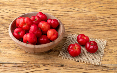 Fototapeta na wymiar Acerolas or Barbados Cherries in a bowl over wooden table