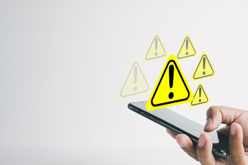 Hand using smartphone with Exclamation mark or Warning sign over white background perfect for Digital Crime,Cyber Security, information security,data protection concept.