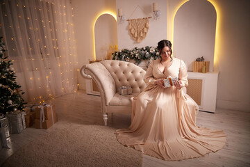 Owerweight elegant Woman at Christmas room. Fat plumb pretty girl in a beautiful dress for a...