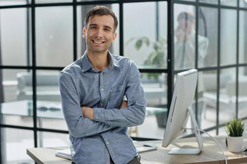 young businessman in the office with his arms crossed