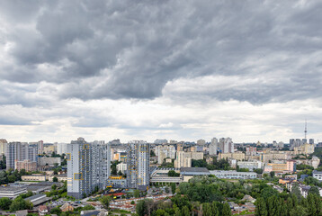 The city landscape, gray clouds over residential multi-storey buildings and parks covered the sky.