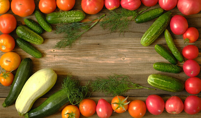 yellow and red tomatoes, cucumbers and zucchini on a wooden background, copy space