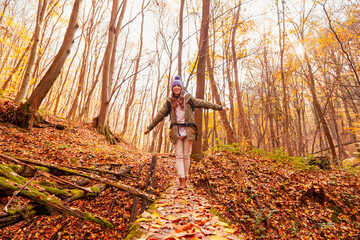 Woman walking down an autumn forest path