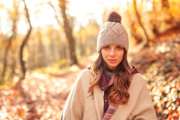 Woman walking through the forest on a sunny autumn day