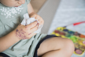 Very cute child cleaning his hands after having been playing with watercolor paints. Concept...