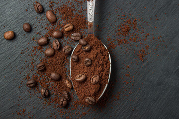 Coffee beans and ground coffee on a black background