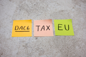 DAC6 (DAC 6), written on sticky note for EU directive on cross-border tax arrangements for information exchange to prevent tax evasion and enhance transparency