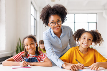 Teacher helping children with schoolwork
