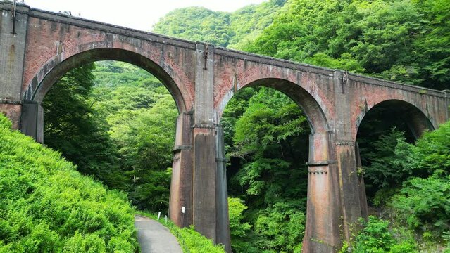 森の中を通る古い鉄橋、めがね橋の空撮｜An old iron bridge passing through the forest. Aerial view of Meganebashi Bridge
