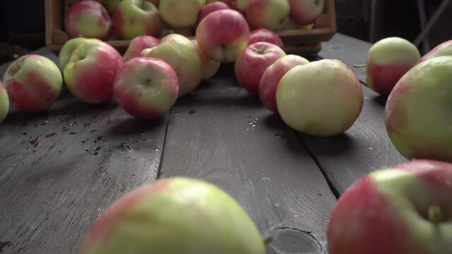 Fresh red apples on a wooden table spill out