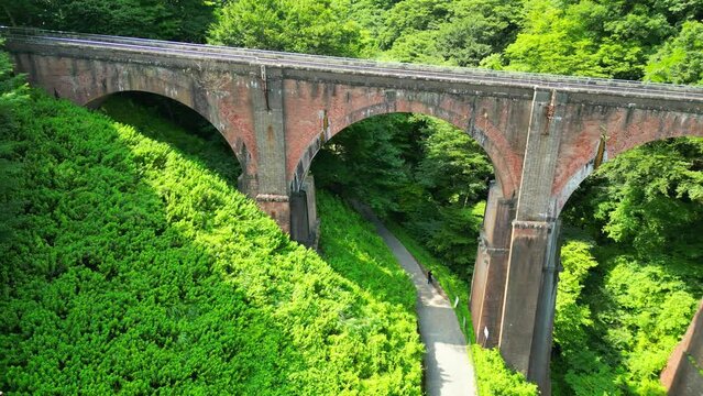 森の中を通る古い鉄橋、めがね橋の空撮｜An old iron bridge passing through the forest. Aerial view of Meganebashi Bridge