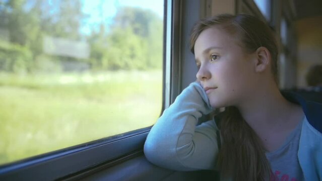 Teen Girl Lost in Thought, Gazing Out of Train Window on a Sunny Summer Day