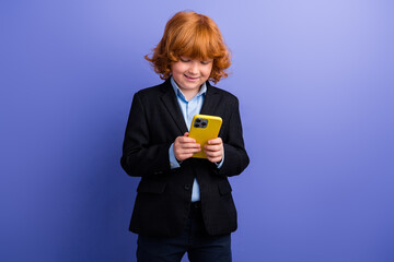 Photo of cheerful satisfied schoolchild use apple iphone gadget texting classmates isolated on violet color background