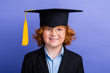 Photo of cheerful intelligent schoolkid toothy smile wear mortarboard graduation hat isolated on violet color background