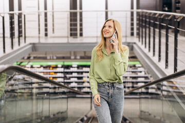 Woman on the escalator talking on her phone at the bulding materials store
